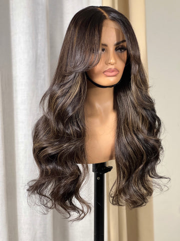 A brown wig with blond highlights, curtain bangs, and a 5x5 closure displayed on a mannequin head.